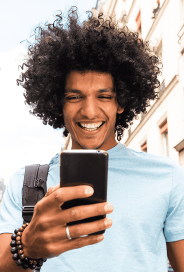 Un homme qui marche dans la rue en souriant au téléphone