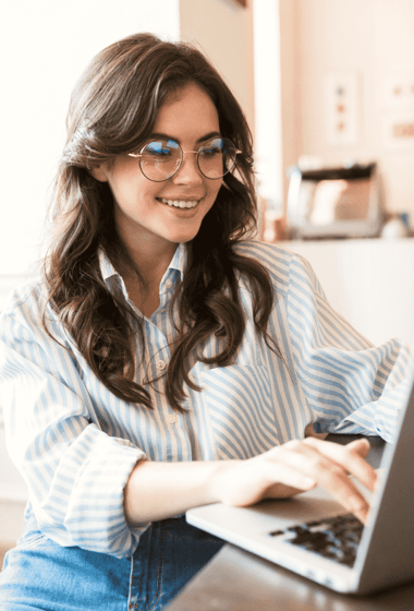 Une femme heureuse qui travaille sur son ordinateur portable